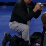 Carl Yahnig was, in the opinion of many people, one of the finest basketball players ever to come out of Ferguson. He went on to play at Cumberland College, then has spent 45 years teaching and coaching at Hopkinsville High School. Carl has made a hobby of photography since high school. Any time his own team does not reach the State Tournament, Carl works the tournament as a photographer. Various newspapers and even the Kentucky High School Athletic Association have used his photos. Carl is shown here in March of 2009 setting his digital camera in the end zone at Rupp Arena in Lexington.