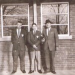 Pausing in this photo is (right) Supervising Principal Howard Moore and two of his star pupils, Bert Minton, center, and Melvin Cox, left. They have just finished taking down the flag at the end of the school day, and are standing in front of the then new administrative & home ec building, now the Ferguson Community Center. Bert would go on to serve as a teacher and coach in the Pulaski County Schools, then as Assistant Superintendant for six years, and Superintendant for 12 years. The boys are shown here in their Key Club blazers.