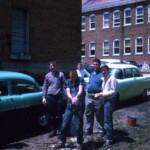 Washing their cars in May 1961 are from left Charles "Tink" Casada, Herbert Beasley, Tommy Wheeler (holding hose), Billy Fowler (in the back, leaning on the hood of the Ford), Bryan Morrow, Bobby Hamm and Leonard Taylor (far right and back, behind the Ford). The cars are, at left, a 1955 Pontiac and, at right, a 1954 Ford Fairlane. The Pontiac, brand new in 1955, cost $2100. Used, in 1960 it cost $600. The Fairlane cost $1800 new in 1954 and used in 1961 it cost $350. A high school student could earn enough in one Summer working in tobacco, in one of the local plants, in timber, or on the railroad, to buy a car, and most did. Ferguson School Archives - Students