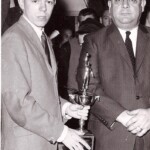 These were the eighth grade cheerleaders during the championship 1966-67 season. They cheered for the team at all eighth grade and ninth grade games but when the eighth graders had to stand in as the high school's junior varsity, the regular JV cheerleaders cheered. These girls were taken on the team bus to all away games. Top to bottom are Debbie Sadler, Rhonda Beckman and Patty Hudson.
These girls were the end of an era : half a century in which truly talented girl athletes spent their time cheering for the boys rather than playing on their own girls sports teams. Shortly after this season, thanks to Federal Title 9, schools were all required to offer girls basketball, volleyball and softball teams. And while some girls still chose to cheer, the best of them spent their weekends travelling to cheering tournaments rather than cheering for their school's boys' teams. Today, many girls in cheerleading have academic eligibility problems, but all five of these girls were honor students.
At right, Coach Dan Omlor accepts the 7th Grade Region Championship trophy after Ferguson beat Somerset 66-56 at the Somerset Gym. Both teams had come into the game 12-0 and it was a sellout, the largest crowd ever to see a 7th grade game in Pulaski County. These were the eighth grade cheerleaders during the championship 1966-67 season. They cheered for the team at all eighth grade and ninth grade games but when the eighth graders had to stand in as the high school's junior varsity, the regular JV cheerleaders cheered. These girls were taken on the team bus to all away games. Top to bottom are Debbie Sadler, Rhonda Beckman and Patty Hudson. These girls were the end of an era : half a century in which truly talented girl athletes spent their time cheering for the boys rather than playing on their own girls sports teams. Shortly after this season, thanks to Federal Title 9, schools were all required to offer girls basketball, volleyball and softball teams. And while some girls still chose to cheer, the best of them spent their weekends travelling to cheering tournaments rather than cheering for their school's boys' teams. Today, many girls in cheerleading have academic eligibility problems, but all five of these girls were honor students. At right, Coach Dan Omlor accepts the 7th Grade Region Championship trophy after Ferguson beat Somerset 66-56 at the Somerset Gym. Both teams had come into the game 12-0 and it was a sellout, the largest crowd ever to see a 7th grade game in Pulaski County.