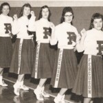 These were the 1959-60 cheerleaders. From left are Lidie Louise Jones, Judy Madge Chitwood, Marlene Hodge, Sandra Ruth Meece and Barbara Ann Meece. These girls had the difficult task of keeping spirits up during a sub 500 season, and even worse it was the school's third straight losing season. But the boys they were cheering for were all sophomores, freshmen and eighth graders. After a Spring, Summer and Fall of hard practices and another year's increase in height and strength, they came back the following season ready and in a vengeful mood. Some of those teams who had kept starters in to run up the score had graduated those starters and Ferguson's boys were just getting warmed up. During the next three years they inflicted the worst losses in school history on 11 different opponents. These girls thus had the honor of ushering in the Last Great Golden Era of Ferguson Basketball. Lidie Jones, seen here as a junior far left, would go on to win every award available to a high school girl in that era : class president, first places in state essay contests, the I Speak For Democracy competition, science fairs, beauty pageants, academic honors including National Merit Scholar status, and a spot on the All Region cheerleading team. She went on to earn a masters degree from UK. These girls were talented athletes. 20 years later, they would almost certainly have played soccer, basketball or softball instead of cheerleading. These were the 1959-60 cheerleaders. From left are Lidie Louise Jones, Judy Madge Chitwood, Marlene Hodge, Sandra Ruth Meece and Barbara Ann Meece. These girls had the difficult task of keeping spirits up during a sub 500 season, and even worse it was the school's third straight losing season. But the boys they were cheering for were all sophomores, freshmen and eighth graders. After a Spring, Summer and Fall of hard practices and another year's increase in height and strength, they came back the following season ready and in a vengeful mood. Some of those teams who had kept starters in to run up the score had graduated those starters and Ferguson's boys were just getting warmed up. During the next three years they inflicted the worst losses in school history on 11 different opponents. These girls thus had the honor of ushering in the Last Great Golden Era of Ferguson Basketball. Lidie Jones, seen here as a junior far left, would go on to win every award available to a high school girl in that era : class president, first places in state essay contests, the I Speak For Democracy competition, science fairs, beauty pageants, academic honors including National Merit Scholar status, and a spot on the All Region cheerleading team. She went on to earn a masters degree from UK. These girls were talented athletes. 20 years later, they would almost certainly have played soccer, basketball or softball instead of cheerleading.