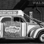 This July 1940 picture shows the Walnut Automobile Dealership in downtown Somerset. They sold Chevrolets. This car is decorated for the annual Fourth of July Parade. Notice the old gas pumps just behind the car.