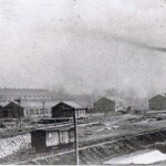 This great photo was provided by the Richardson family. It shows the full Ferguson Maintenance Yards with all buildings still in place on a dreary November afternoon. Maintenance has already been moved to Chattanooga so there is little activity but the heat is still on in all buildings, as indicated by the smoke coming from the stack, which extends up from a coal fired furnace. This is what the yards looked like from the top floor of Ferguson School. The track in the lower right is one of the mainline tracks running right behind the school. In those days the mainline consisted of two tracks, one for trains heading North and one for trains heading South.
For a view inside the large complex to the left, which was the engine house, see top right. The full "shift" poses in front of a 2-6-2 steam engine having just been reconditioned. A shift was one eight hour work group. The yard operated 24 hours a day seven days a week, with midnight - 8 am, 8 - 4 pm and 4 pm - midnight shifts.