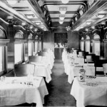 This is the interior of the car shown in the previous photo. A railroad dining car was a rolling version of a very high class restaurant. But it had its own ways of operating. The menu was limited to only a few items. You could order a meat, fish or chicken entree and two sides from a list of four or six. You had a choice of three salads and three desserts. The beverage list would include coffee, milk, tea, a white or red wine, apple or tomato juice. However, within this limited menu, the quality would be outstanding. You could not order a better meal in the finest restaurants in Chicago, New York or Atlanta. The meal was included in your ticket. An attendant would come to your seat and offer you a choice of seating times. Breakfast was served from 6 to 9, lunch from 11:30 to 1:30, and dinner from 4:30 to 7:30. Seatings were every half hour. Then the attendant would hand you a menu and take your order. So when you arrived at the car at the chosen time, you were immediately seated and the food was ready. Dishes, bowls, cups and glasses were specially made to hold foods and drinks on the moving trains.
