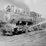 The steam in the boiler was under pressure. When the engine came into Ferguson Yard for service, the first step was to release the pressure by draining the steam and water. Then the men would refill the boiler with water and refill the tender (the smaller car being towed behind the engine) with wood or coal before sending the engine back on the road. The firepit was at the front of the cab, shown here with someone at the window. The fireman would shovel the coal or wood from the tender into the firepit. The roaring fire would heat the water, converting it to steam, which was used to drive the pistons, which pushed the rods, which turned the wheels. The steam locomotive was a tremendous piece of engineering which hauled freight and passengers across America for 200 years before being sidelined by diesel and electric locomotives. It will probably go down in history as one of the greatest machines ever built.